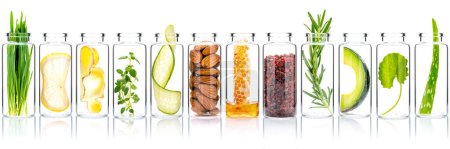 Photo for Homemade skin care with natural ingredients avocado ,aloe vera ,cucumber ,himalayan salt  ,honeycomb ,almonds ,centella asiatica, ginger slice and rosemary  in glass bottles isolate on white background. - Royalty Free Image