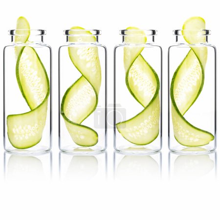 Photo for Homemade skin care cucumber slice twist in glass bottles isolated on white background. - Royalty Free Image