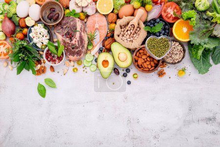 Concepto de dieta baja en carbohidratos cetogénicos. Ingredientes para la selección de alimentos saludables establecidos sobre fondo de hormigón blanco.
