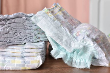 a pile of baby diapers on a wooden table