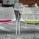 metal white chairs with colored cushions stand outdoors