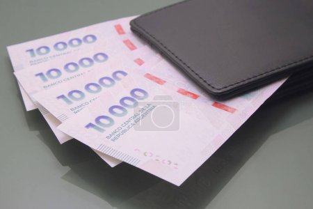 Argentinisches Geld - Währung Argentiniens, argentinische Pesos, zehntausend Pesos in bar in einer Brieftasche auf dunklem Hintergrund. Bares Geld