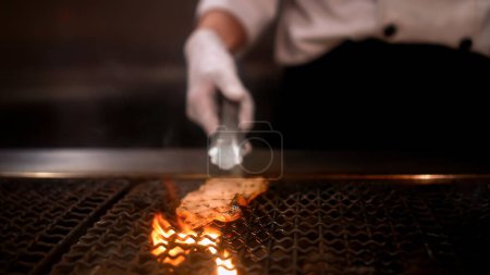 Foto de Un chef profesional cocina carne Wagyu premium y fresca, cortada en rodajas finas y servida con barbacoa japonesa Sukiyaki. Yakiniku estilo japonés. Experiencia de barbacoa Shabu. - Imagen libre de derechos