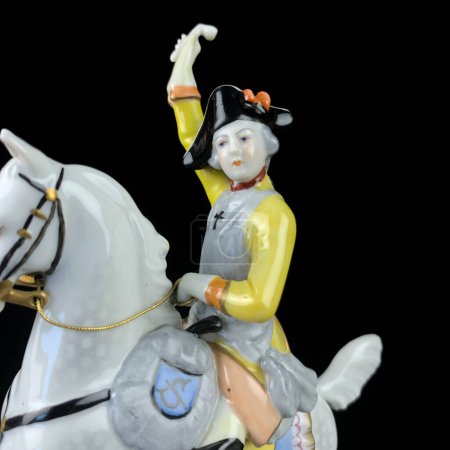 Téléchargez les photos : Ceramic figurine of a male commander on a horse on a black background. porcelain figure of a general - en image libre de droit