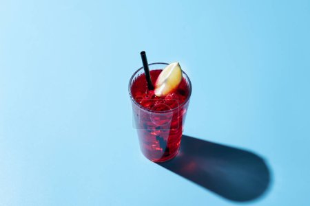 Cape Codder cocktail with vodka, cranberry juice and lime on blue background