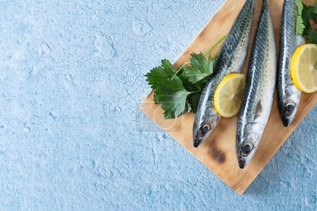 Photo for Raw mackerel fish salt around on blue background. Top view. Copy space - Royalty Free Image