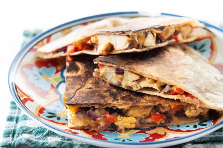 Mexican quesadilla with chicken, cheese and peppers on white marble background