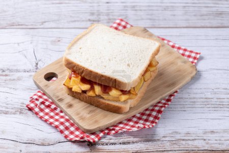 Photo for Traditional British chip butty (french fry sandwich) on wooden table - Royalty Free Image