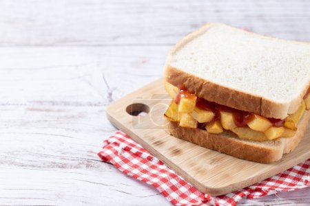 Photo for Traditional British chip butty (french fry sandwich) on wooden table - Royalty Free Image