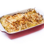 Potato gratin baked with cream and cheese isolated on white background