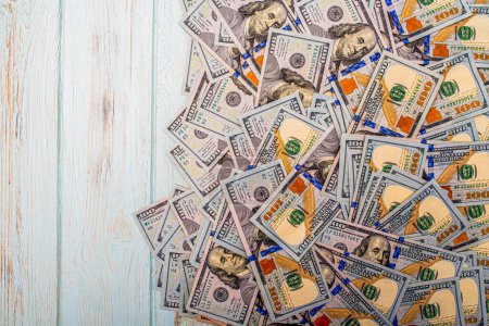 Téléchargez les photos : American currency on a wooden background. One hundred dollar bills on a blue background. - en image libre de droit