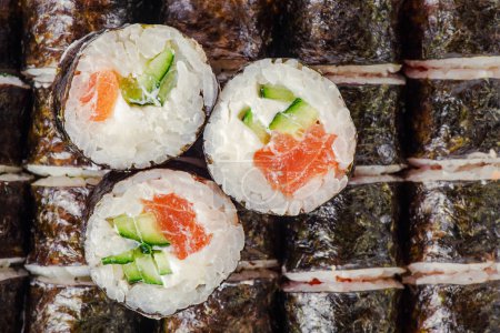 Photo for Delicious Japanese food rolls. Rolls with cucumber, rice, Philadelphia cheese, salmon. - Royalty Free Image