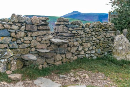 Téléchargez les photos : Escalade sur un mur de pierre sèche près de Keswick dans le Lake District - en image libre de droit