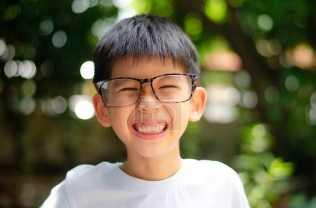 Foto de Asiático niño 6 años de edad retrato, sonriendo con feliz conceptual, usar gafas de ojo, usar camisa blanca - Imagen libre de derechos