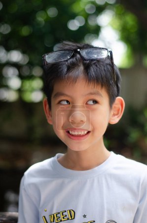 Foto de Asiático niño 6 años de edad retrato, sonriente y tonto con feliz conceptual, usar gafas de ojo, usar camisa blanca - Imagen libre de derechos