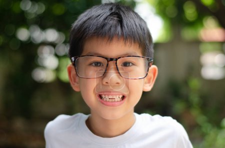 Foto de Asiático niño 6 años de edad retrato, sonriente y tonto con feliz conceptual, usar gafas de ojo, usar camisa blanca - Imagen libre de derechos