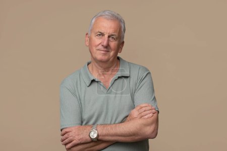 Photo for Handsome older man is posing in photo studio on brown background. - Royalty Free Image