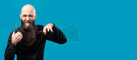 Photo for Funny bald barber with long beard and scissors is posing in studio. - Royalty Free Image