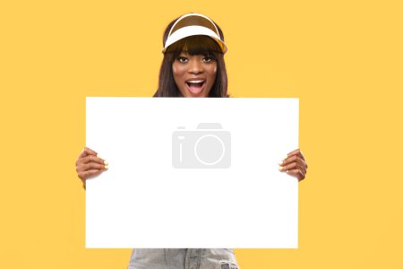Photo for Attractive female is holding a white board on isolated yellow background. - Royalty Free Image