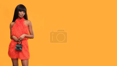 Photo for Very fashionable brunette in red dress and high heels on orange background. - Royalty Free Image