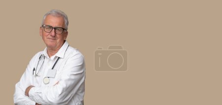 Photo for Older doctor in eyeglasses with stethoscope and white uniform on light brown background. - Royalty Free Image