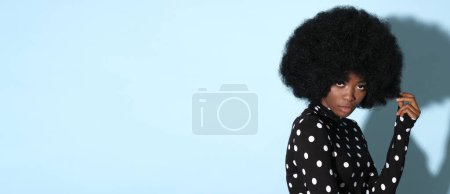 Foto de Mujer afroamericana sobre fondo azul claro con lugar para texto. - Imagen libre de derechos