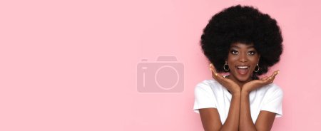 Foto de Mujer afro americana feliz con lugar de texto sobre fondo rosa. - Imagen libre de derechos