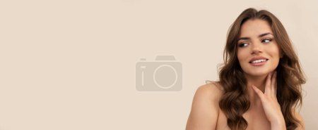 Photo for Very attractive young woman with curly brown hairs on light brown background. - Royalty Free Image