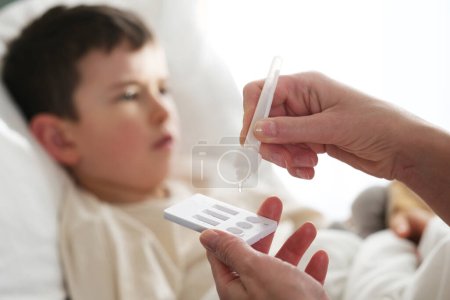 Téléchargez les photos : A little boy is sick, a combo antigen test (covid-19, flu a b, RSV) is needed for proper diagnosis. - en image libre de droit