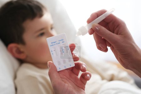 Foto de A little boy is sick, a combo antigen test (covid-19, flu a b, RSV) is needed for proper diagnosis. - Imagen libre de derechos