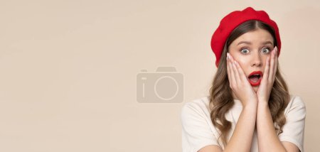 Téléchargez les photos : Shocked young woman in red beret on isolated light brown background. - en image libre de droit