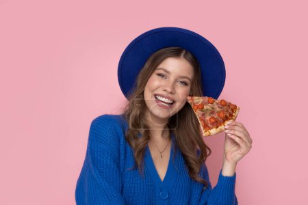 Photo for Happy woman eat slice of pizza on pastel pink background with free space for text. - Royalty Free Image