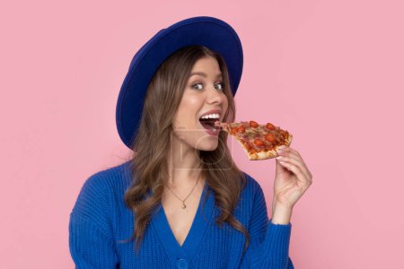 Photo for Happy woman eat slice of pizza on pastel pink background with free space for text. - Royalty Free Image