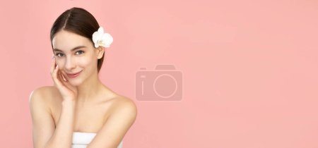 Foto de Hermosa mujer joven con la piel limpia sobre fondo rosa aislado. - Imagen libre de derechos