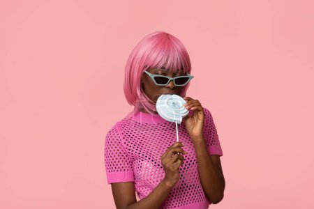 Téléchargez les photos : Mignon modèle féminin avec des cheveux roses et sucette sur fond rose pastel isolé. - en image libre de droit