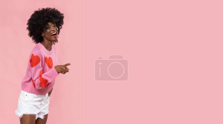 Foto de Preciosa mujer africana en suéter de corazón sobre fondo rosa. - Imagen libre de derechos