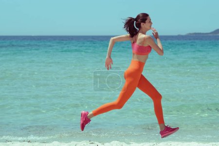 Photo for Beautiful woman jogging on the beach. Fashionable styling and retro colors! - Royalty Free Image