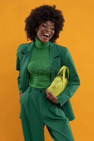 Téléchargez les photos : Beau modèle avec une coiffure afro et un costume vert sur fond jaune. - en image libre de droit