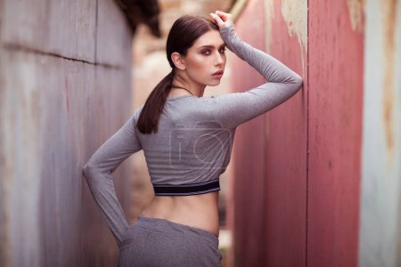 Photo for Sexy slim brunette in sport outfit in industrial background. - Royalty Free Image