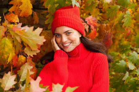 Foto de Hermosa morena en un paisaje de otoño con un sombrero rojo y bufanda. - Imagen libre de derechos
