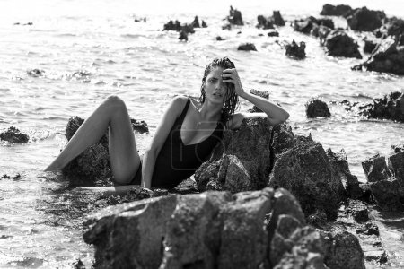 Téléchargez les photos : Photo sensuelle de la belle brune sur la plage rocheuse. - en image libre de droit