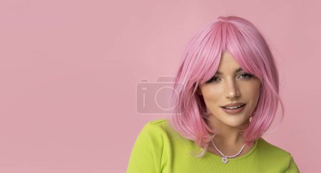 Photo for Cute young woman with pink hair and bright green dress on isolated pink background. - Royalty Free Image