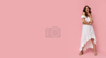 Foto de Mujer joven muy atractiva en vestido blanco sobre fondo rosa aislado. - Imagen libre de derechos