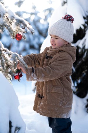 Téléchargez les photos : Maman et son fils s'amusent beaucoup à faire une promenade hivernale, à prendre le thé et à décorer le sapin de Noël. - en image libre de droit