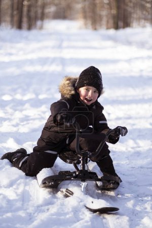 Foto de Un niño jugando con un trineo en invierno. - Imagen libre de derechos