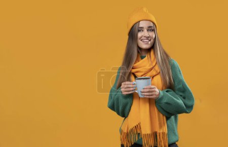 Photo for Very positive young woman in orange cap and scarf on isolated background. - Royalty Free Image