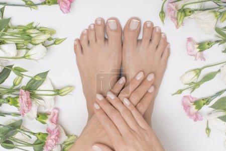 Foto de Hermosos pies femeninos con flores en el fondo. - Imagen libre de derechos