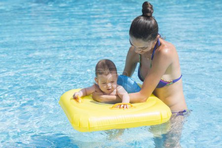Téléchargez les photos : Mère et fils jouant dans la piscine. - en image libre de droit