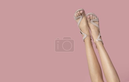 Photo for Slim female legs on isolated pink background. - Royalty Free Image