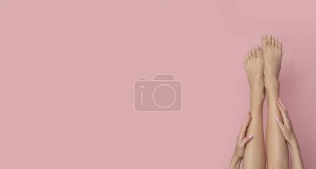 Téléchargez les photos : Jambes femelles minces sur fond rose isolé. - en image libre de droit
